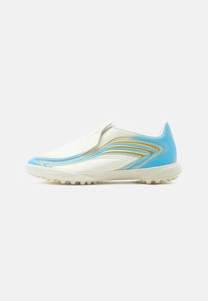 Zapatilla deportiva sin cordones en blanco y azul claro con patrones ondulados dorados y azules y suela texturizada.