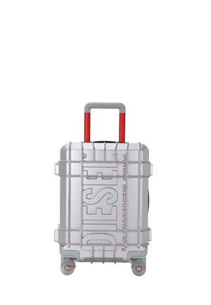 Valigia rigida argento con manico estensibile rosso, quattro ruote e marchio "DIESEL" in rilievo sul davanti.