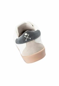 Witte sneaker met grijze suède hiel en beige accenten. Beschikt over een rubberen zool, contrasterende texturen en een logo aan de achterkant.
