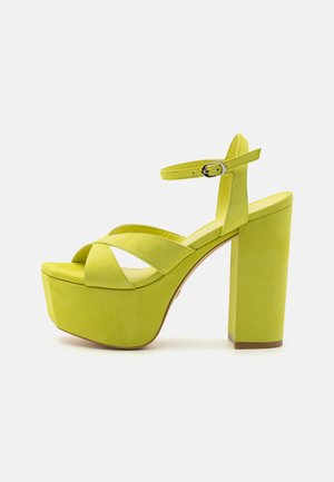 Sandale cu toc înalt din suede verde, cu platformă, design cu curea încrucișată, curea ajustabilă la glezna și toc gros.