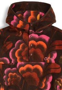Pull en polaire marron foncé avec un motif floral coloré en rose, orange et jaune. Dispose d'un col montant et d'une fermeture à bouton-pression.