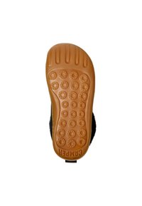 Suela de goma marrón con una superficie patterned, que presenta puntos de agarre circular. El zapato tiene un empeine negro y esponjoso y un logotipo de marca visible.