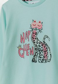Sudadera verde claro con un gráfico de un gato que lleva una máscara, con detalles de estampado de leopardo en rosa y negro y el texto destacado "REINA DEL SUEÑO".