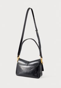 Sac à main en cuir noir avec une forme structurée, une poignée tressée et une bandoulière réglable. Des accessoires en métal doré rehaussent le design.