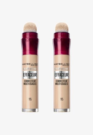 Deux tubes de correcteur Maybelline, avec un liquide beige et des applicateurs en éponge ronds, dotés de bouchons rouges et d'étiquettes argentées indiquant la teinte 115.
