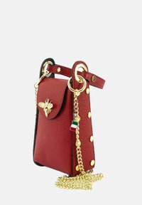 Rode leren handtas met een gouden bijaccent, kettingriem en gouden hardware. Kenmerkt zich door zwarte afwerking en decoratieve gouden studs.