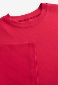 Rode katoenen sweatshirt met een ribbelboord en zichtbare stiksels. Heeft een grote voorzak, een zachte textuur en een relaxte pasvorm.