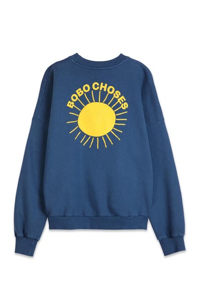 Blå sweatshirt med en stor gul solgrafik med strålar och texten "BOBO CHOSES!" i ett lekfullt typsnitt på baksidan.