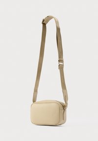 Mala de tiracolo bege com forma retangular, textura de couro suave, alça ajustável e fecho de correr no topo.