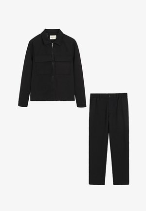 Veste noire avec fermeture éclair et deux poches poitrine ; pantalon noir assorti avec jambe droite et fermeture à bouton à l'avant. Tissu texturé.