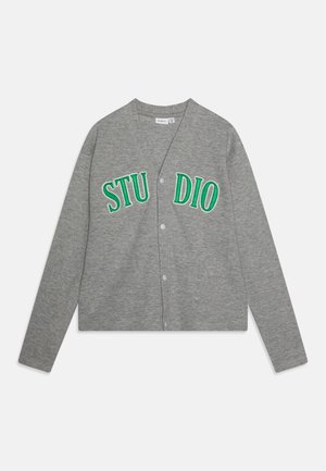 Cardigan grigio con maniche lunghe, chiusura a bottoni e testo ricamato "STUDIO" verde sul davanti. Realizzato in un morbido tessuto testurizzato.