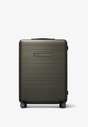 Valise rigide de couleur vert foncé, présentant une surface texturée avec des rainures horizontales, une poignée supérieure et quatre roues noires pour la mobilité.
