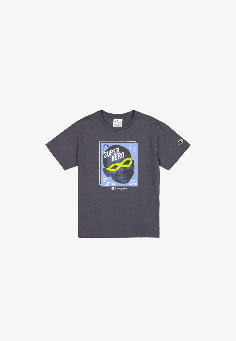 Camiseta de algodón gris con una ilustración gráfica de un niño sonriente con gafas de sol. El texto dice "Soy un SUPERHÉROE" con acentos coloridos.