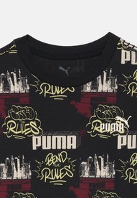 Svart bomull T-skjorte med fargerik graffitistil og grafikk av urbane horisonter. Ribbete rund hals og Puma-logo som aksent.
