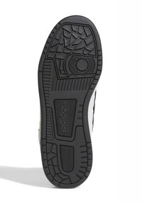 Suola di scarpa in gomma nera con motivo testurizzato, caratterizzata da scanalature e grip per la trazione. Logo visibile sul lato.