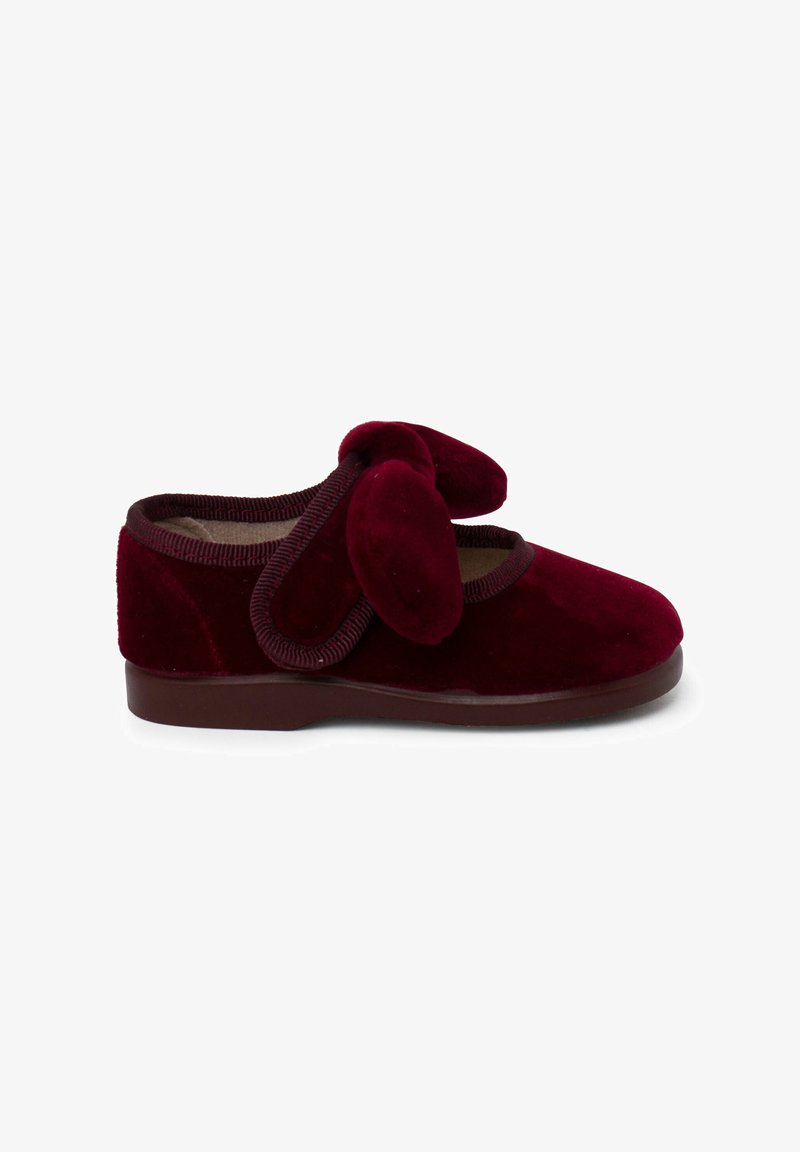 Chaussure en velours bordeaux avec un bout rond et des accents doux en forme d'oreilles de lapin, dotée d'une semelle en caoutchouc marron et d'un bord texturé.