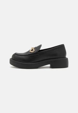 Mocasini negri din piele, cu vârf rotunjit, talpă plată și un accent în formă de inimă auriu pe partea superioară. Design simplu și textură netedă.