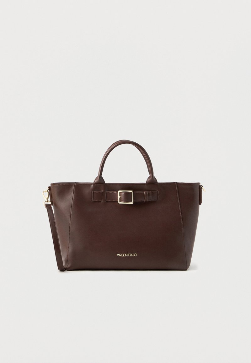 Bolsa de couro castanho com formato estruturado, apresentando um detalhe de fivela, alças duplas e uma alça de ombro ajustável. Ferragens em tom dourado.