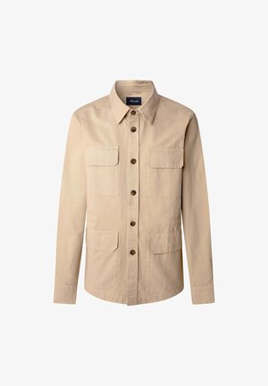 Giacca camicia in cotone beige con maniche lunghe, chiusura frontale a bottoni e quattro tasche applicate. Presenta un colletto a punta e bottoni marroni.