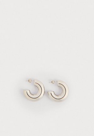 Kovové kruhové náušnice s zakřiveným designem, s lesklým stříbrným povrchem a tenkými černými akcentovými linkami. Zapínání na post.