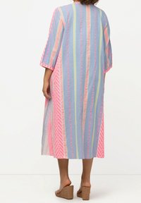 Pruhovaný kaftan v modré, růžové a žluté barvě, vyrobený z lehkého materiálu. Má tříčtvrteční rukávy a volnější střih.