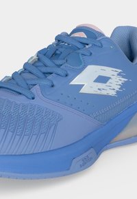 Blue athletic shoe with textured toe, lace-up design, white stylized logo on side, and cushioned collar on a light background.