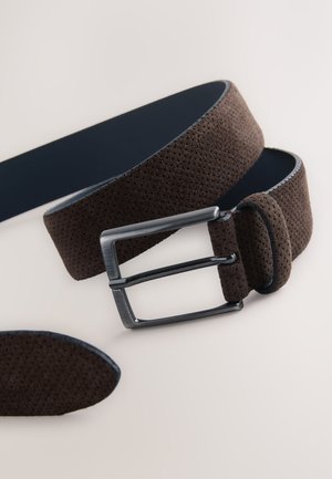 Brauner perforierter Gürtel mit glatter, marineblauer Unterseite. Verfügt über eine silberne Metallschnalle und eine passende Lederschlaufe. Strukturierte Oberflächendetails.