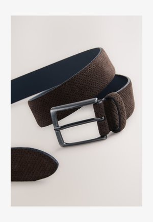 Brauner perforierter Gürtel mit glatter, marineblauer Unterseite. Verfügt über eine silberne Metallschnalle und eine passende Lederschlaufe. Strukturierte Oberflächendetails.