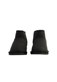 Botas negras hasta el tobillo hechas de ante. Presentan un diseño sencillo, punta redonda, textura suave y detalles cosidos a lo largo de las costuras. Suela plana.