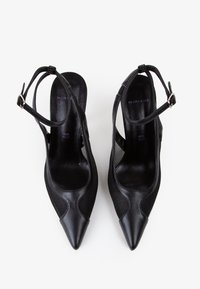 Zapatos de tacón alto negros con punta afilada, con acabados de cuero liso y malla, correas de tobillo ajustables y una silueta elegante.