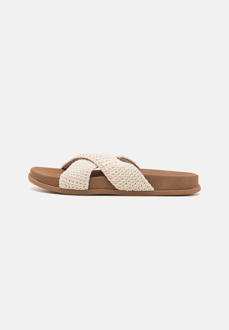 Sandale plate marron avec des brides croisées épaisses en tissu crème tissé et une semelle rembourrée, vue de côté sur fond blanc.