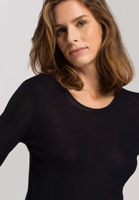 Schwarzes Langarmshirt mit rundem Ausschnitt, aus leichtem, leicht transparentem Stoff, mit einer glatten Textur und figurnahem Design.