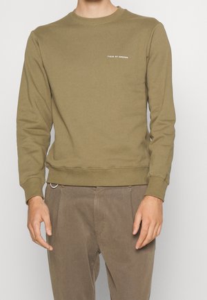 Sweatshirt à col rond vert olive en tissu doux avec des poignets et un ourlet côtelés, arborant un petit logo blanc sur la poitrine.