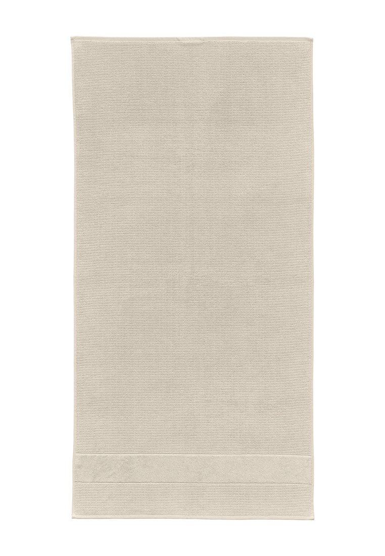 Beige Baumwollhandtuch mit strukturiertem Gewebe, das am unteren Ende mit einem glatten Akzentband versehen ist. Es misst etwa 70 cm x 140 cm.