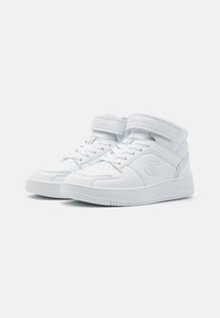 Hvite høye sneakers med glatt skinnutside, som har perforeringer på tåen, snøring og en borrelåsrem rundt ankelen.