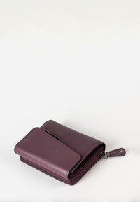 Portafoglio in pelle viola con finitura testurizzata, dotato di chiusura con zip, patta frontale e anello laterale per l'attacco.
