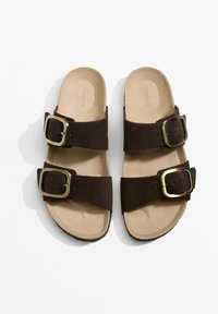 Barna szarvasbőr szandál két széles pánttal és aranyszínű csatokkal. Párnázott talpbetétek és texturált gumitalp a jó tapadásért. Méret 37.