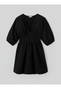 Robe courte noire avec un décolleté en V profond, des manches bouffantes et un tissu texturé présentant un motif subtil. La taille froncée crée une silhouette évasée.