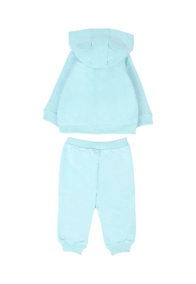 Jasnoniebieski dwuczęściowy zestaw składający się z bluzy z kapturem z kieszenią kangurką oraz spodni z elastycznym pasem i ściągaczami na końcach. Miękka tekstura materiału.