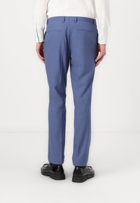 Light blue dress pants with a tailored fit, two back pockets, and a smooth texture, paired with black dress shoes.