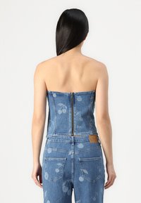 Denim stroppeløs topp med en tettsittende design, lyseblå farge, bakre glidelås og subtilt kirsebærblomstmønster.