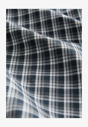 Audums ar tumši zilu un baltu rūtainu rakstu. Audums izskatās mīksts ar vieglu spīdumu un skaidrām režģa līnijām.