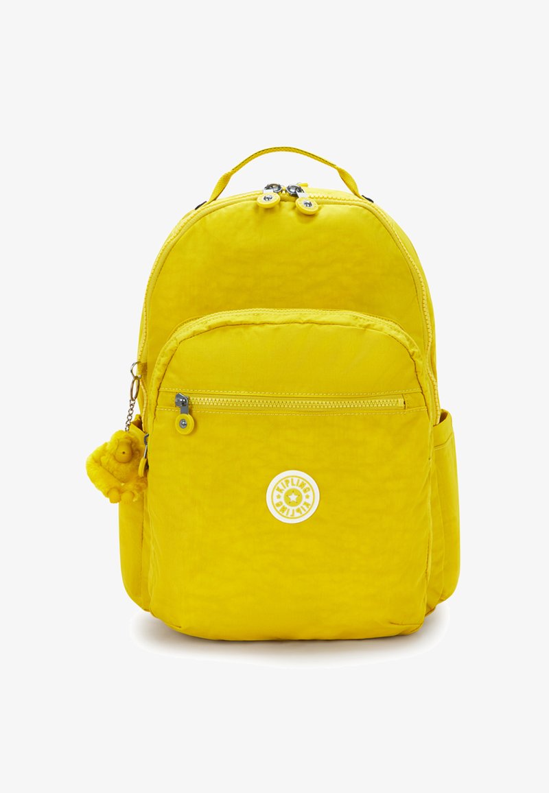 Sac à dos en nylon jaune de forme arrondie, avec deux compartiments zippés, une poche avant et un détail charmant en peluche. Il comporte un patch logo.