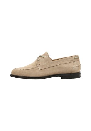 Mocasín de hombre beige de ante con costura moc toe, cordones con dos ojales y suela de goma negra, mostrado de perfil sobre fondo blanco.
