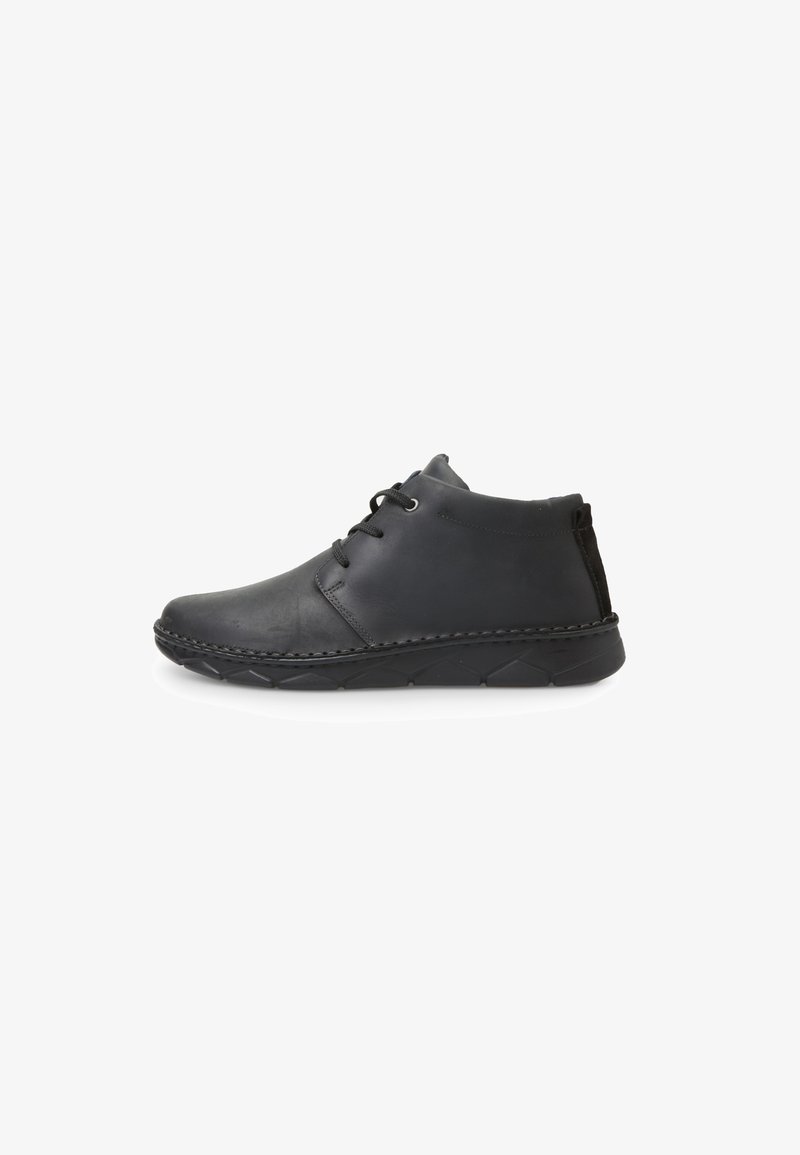 Bottines en cuir noir avec un bout arrondi, un laçage, et une semelle en caoutchouc texturée. Présente une couture le long de la semelle.