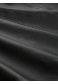 Tela negra texturizada con un acabado suave y ligeramente brillante, que presenta suaves pliegues y arrugas en todo el material.