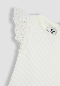 Top bianco a coste con rouches in pizzo sulle spalle. Il tessuto appare morbido, con una texture liscia e un design casual.