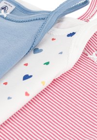 Three tank tops: light blue, white with multicolored heart prints, and red-striped. Features soft fabric and decorative trims.