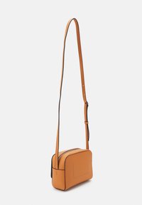 Small rectangular crossbody bag in orange leather with black trim, featuring a zip closure and adjustable strap. Smooth texture, minimal design.