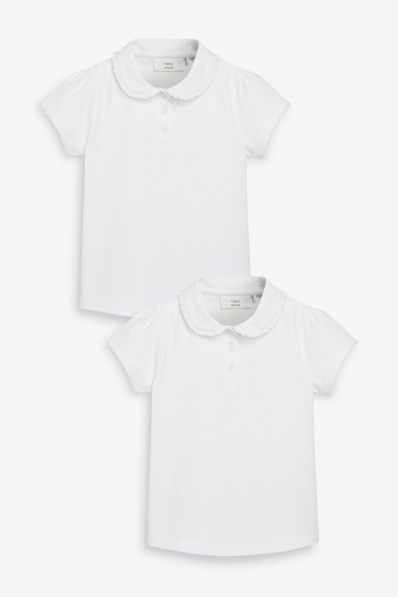 Zwei weiße Poloshirts mit kurzen Puffärmeln, Rüschensaum und Knopfleisten mit drei Knöpfen. Aus weichem Baumwollstoff gefertigt.